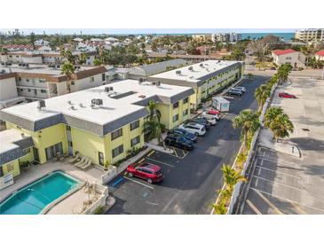 Aerial view of a condo complex featuring a pool, multiple buildings, and ocean views at 6703 Midnight Pass Rd # 108B, Sarasota, FL 34242