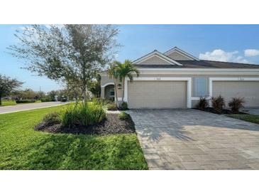 Charming single-Gathering home with a two-car garage, brick paved driveway, and neatly landscaped yard at 7668 Registrar Way, Sarasota, FL 34243