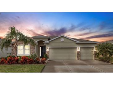 Charming single-story home with a well-manicured lawn, lush landscaping, and a spacious three-car garage at 452 Tierra Verde Way, Bradenton, FL 34212