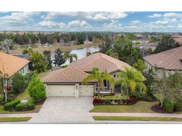Stunning lakefront home featuring lush landscaping, tile roof, and a three-car garage in a beautiful community at 16621 Berwick Ter, Lakewood Ranch, FL 34202