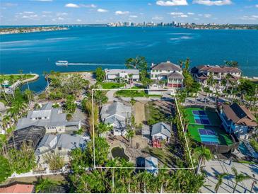 Breathtaking waterfront property with lush landscaping, mature trees, and an in-ground pond at 624 Norsota Way, Sarasota, FL 34242