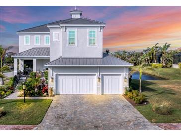 Beautiful two-story home with a two-car garage and a brick driveway near lush landscaping and waterfront at 5204 Title Row Dr, Bradenton, FL 34210