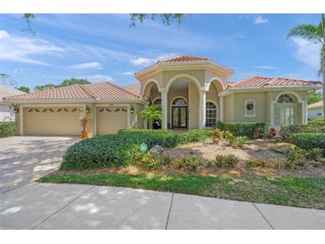 Charming home showcasing lush landscaping, a three-car garage, and inviting front entryway at 790 Shadow Bay Way, Osprey, FL 34229