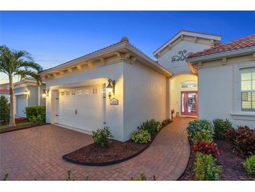 Charming home featuring a tile roof, brick driveway, and well-manicured landscaping at 11816 Altamonte Ct, Venice, FL 34293