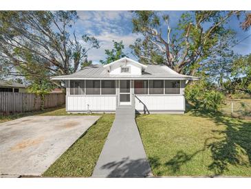 Charming home with a screened front porch, mature trees, and a well-maintained front lawn at 1717 32Nd St, Sarasota, FL 34234