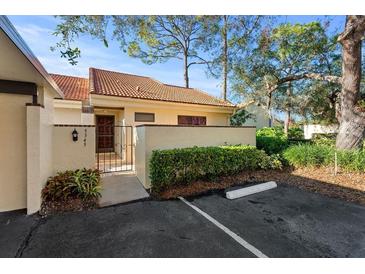 Well-maintained exterior with a tile roof, manicured landscaping, and a gated front entrance at 5343 Huntingwood Ct # 33, Sarasota, FL 34235