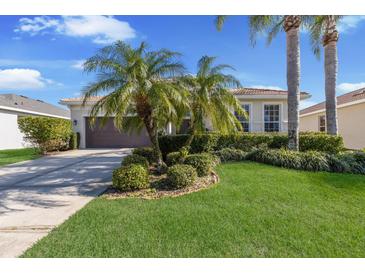 Beautiful home featuring a well-manicured front lawn and mature palm trees enhancing curb appeal at 6914 45Th E Ter, Bradenton, FL 34203
