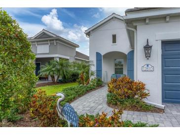 Charming home with well-maintained landscaping, paver walkway, and blue shutters providing an inviting curb appeal at 12810 Seasong Ter, Bradenton, FL 34211