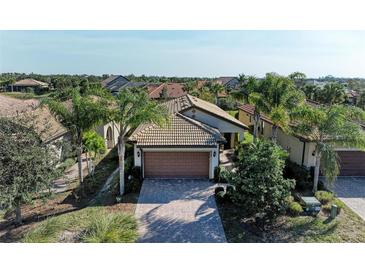 Charming single-story home with a well-manicured lawn, palm trees, and a brick driveway at 6739 Haverhill Ct, Lakewood Ranch, FL 34202