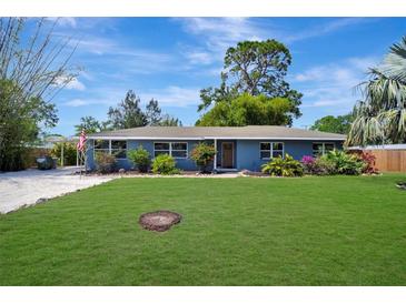 Charming single-story home with a well-manicured lawn, lush landscaping, and a blue exterior at 3902 11Th W Ave, Bradenton, FL 34205