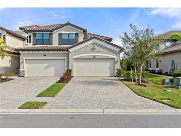 Charming two-story townhome features a private two-car garage and beautiful Mediterranean-style architecture at 6065 Worsham Ln # 104, Bradenton, FL 34211