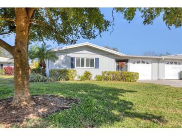 Charming single-story home featuring well-maintained landscaping, a lovely green lawn, and decorative shutters at 7304 11Th W Ave, Bradenton, FL 34209