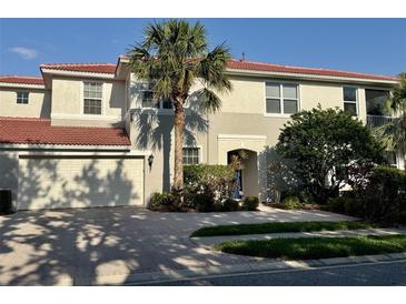 Beautiful two-story home featuring a two-car garage, a red tile roof and lush tropical landscaping at 9606 Sea Turtle Ter # 101, Bradenton, FL 34212