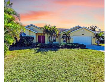 Charming single-story home with a lush green lawn, complemented by tropical landscaping and a two-car garage at 4581 E Dover Street Cir, Bradenton, FL 34203