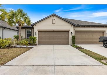 Home featuring a large concrete driveway and a well-maintained front lawn at 6077 Amberly Dr, Bradenton, FL 34208
