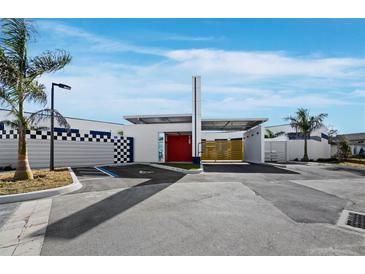 Modern building with a checkerboard wall, red door, and palm trees at 8100 Ciboney Ct # 9, Sarasota, FL 34240