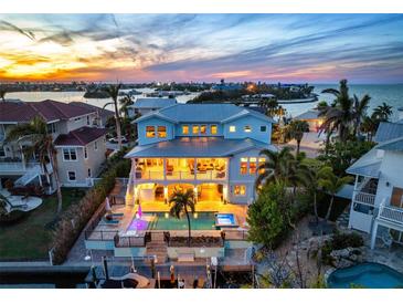 Stunning coastal home with pool, dock, and bay views at sunset at 718 Key Royale Dr, Holmes Beach, FL 34217