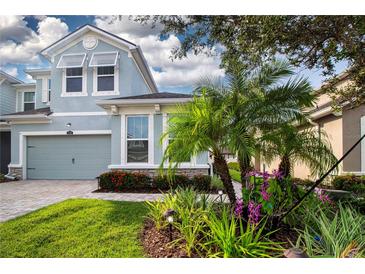 Charming two-story home featuring a lovely garden, well-manicured lawn and a two-car garage at 11728 Meadowgate Pl, Bradenton, FL 34211