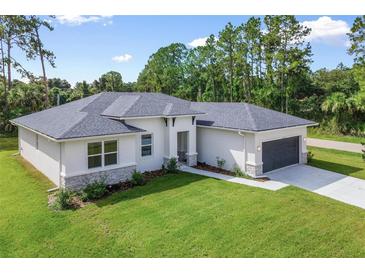 Modern single-story home featuring a lush green lawn, new roof, neutral color palette, and an attached two-car garage at 1342 Shaker Ln, North Port, FL 34286