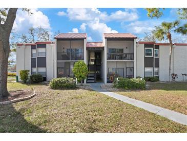 Inviting condo exterior featuring a red tile roof, balconies, and landscaped grounds at 3201 Beneva Rd # 204, Sarasota, FL 34232