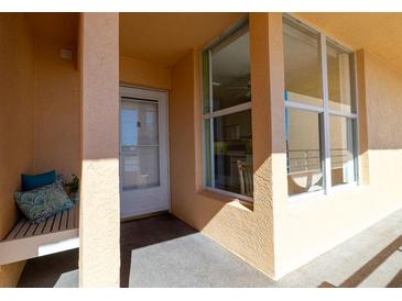 Inviting entrance featuring a bench with pillows, a white door, and a large window showcasing the interior at 4570 Pinebrook Cir # 303, Bradenton, FL 34209