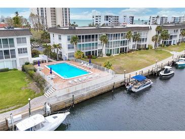 Beautiful waterfront condo complex with community pool, boat docks, and tropical landscaping at 4350 Chatham Dr # 208, Longboat Key, FL 34228