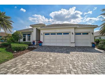 Beautiful home with a spacious three-car garage, meticulously landscaped yard and paver driveway at 8261 Grande Shores Dr, Sarasota, FL 34240