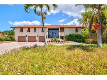 Beautiful two-story home with large windows, three-car garage, and lush landscaping at 424 Cezanne Dr, Osprey, FL 34229