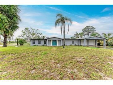 Charming single-story home featuring a spacious front yard, complemented by lush greenery and a welcoming teal-colored front door at 800 Riviera St, Venice, FL 34285