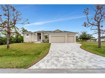 Charming one-story home with a three car garage and a brick paver driveway at 15350 Ancel Cir, Port Charlotte, FL 33981