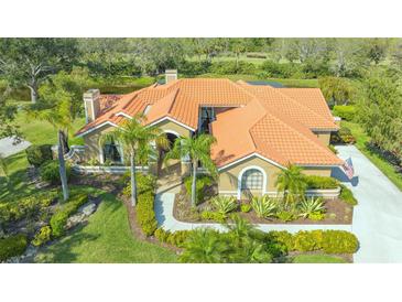 Stunning single-story home with a clay tile roof, beautiful landscaping, and a curved walkway at 4221 Escondito Cir, Sarasota, FL 34238