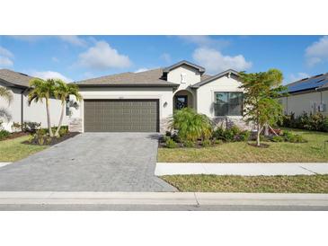 Charming single-story home with a two-car garage, beautifully landscaped yard, and neutral color palette at 1889 Saddlewood Cir, Port Charlotte, FL 33953