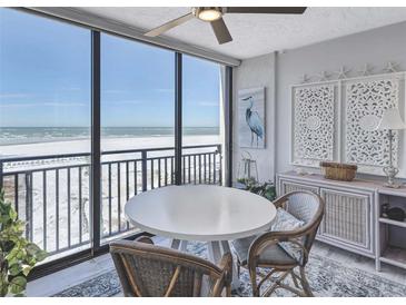 Bright dining area featuring stylish wicker chairs, coastal decor, and panoramic ocean views at 20 Whispering Sands Dr # 306, Sarasota, FL 34242