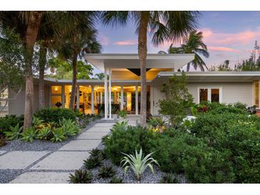 Modern home exterior featuring lush landscaping, palm trees, and a welcoming walkway at 117 S Polk Dr, Sarasota, FL 34236