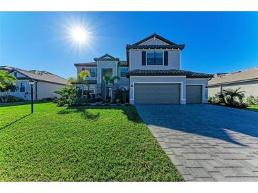 Two-story home boasts a three-car garage, well-manicured lawn, and elegant landscaping at 4852 Coastal Days Ln, Bradenton, FL 34211