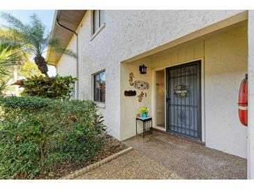 Inviting entrance with decorative accents, a storm door and lush landscaping at 3500 El Conquistador Pkwy # 119, Bradenton, FL 34210