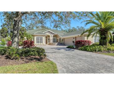 Well-maintained home with a meticulously landscaped front yard and a brick-paved driveway, offering curb appeal at 12471 Natureview Cir, Bradenton, FL 34212