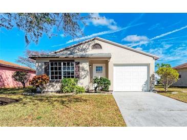 Charming single-story home featuring a well-maintained lawn, lush landscaping, and attached two-car garage at 20032 Sancraft Ave, Port Charlotte, FL 33954