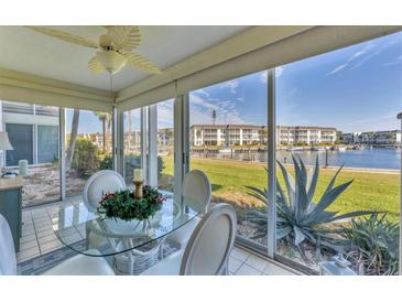 Bright dining area featuring a glass table and picturesque waterfront views from large windows at 4350 Chatham Dr # E106, Longboat Key, FL 34228