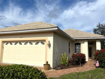 Charming single-story home with a tile roof, a well-manicured lawn and landscaping at 7619 Teal Trace, Bradenton, FL 34203