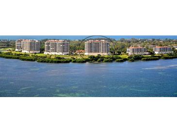 Scenic aerial view of beachfront condos overlooking serene waters and lush green landscapes at 3060 Grand Bay Blvd # 154, Longboat Key, FL 34228