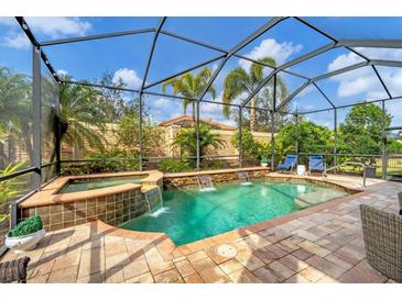 Screened-in pool and spa area featuring waterfall features and lush landscaping for a private oasis at 5116 Tivoli Run, Bradenton, FL 34211