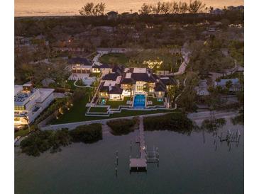Stunning waterfront estate featuring a private dock, pool, and lush landscaping, perfect for luxury living at 8501 Midnight Pass Rd, Sarasota, FL 34242