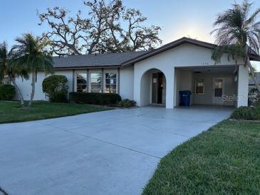 Inviting single-story home featuring an attached carport and a well-maintained front lawn at 1546 Grand Blvd # 108, Sarasota, FL 34232