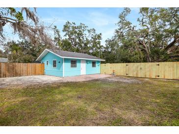 Charming light blue home featuring a brick patio and newly installed wood fence at 3200 Tobero Ln, Sarasota, FL 34235