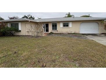 Single story home featuring a two car garage and a lawn in need of maintenance at 600 S Neponsit Dr, Venice, FL 34293