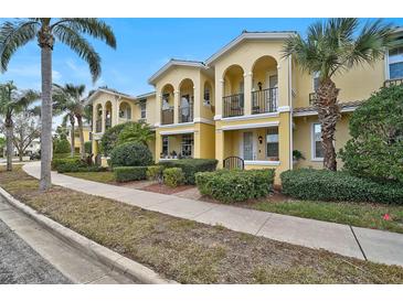 Charming townhomes featuring private balconies, lush landscaping, and bright yellow facades at 1605 Napoli W Dr, Sarasota, FL 34232