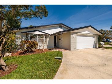Charming single-story home featuring a brick facade, attached garage, and well-manicured landscaping on a sunny day at 5500 Bayou Grande Ne Blvd, St Petersburg, FL 33703