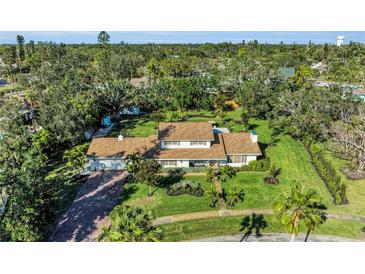 Expansive aerial view of landscaped property featuring a large home, mature trees, and lush green lawn at 7820 Seville Cir, Bradenton, FL 34209