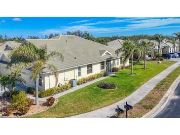 Charming single-story home with lush landscaping, well-manicured lawn, and a quaint walkway at 9367 Hawk Nest Ln, North Port, FL 34287